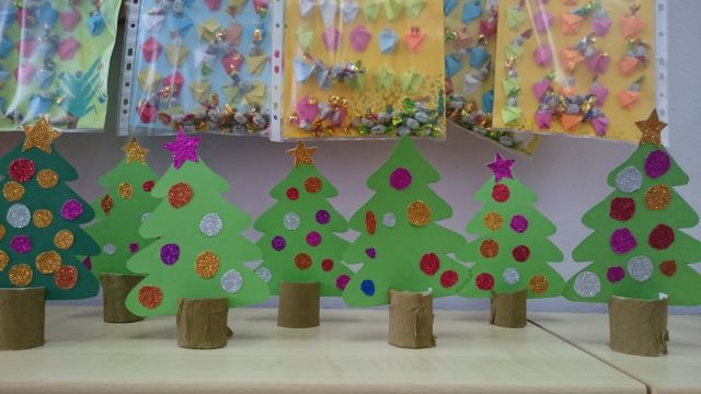 Zdjęcie prac wykonanych przez uczniów – papierowe choinki ozdobione bombkami z brokatu.