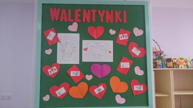 Zdjęcie przedstawia udekorowaną tablicę  napisem: ,,Walentynki’’ oraz wyciętymi z papieru kolorowymi sercami i kartkami walentynkowymi.
