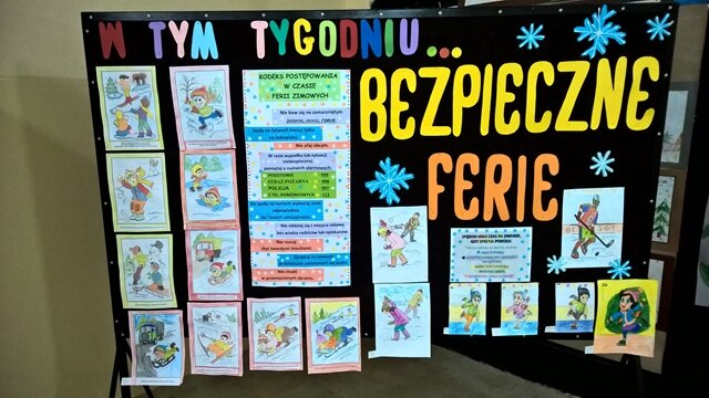  Dekoracyjna tablica z napisem „W tym tygodniu... bezpieczne ferie”. Do tablicy przypięty jest kodeks postępowania w czasie ferii zimowych i rysunki różnych zimowych zabaw.