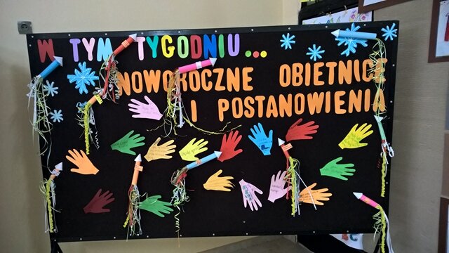 Na tablicy kolorowe dłonie i rakiety oraz tytuł „ Noworoczne obietnice i postanowienia”.