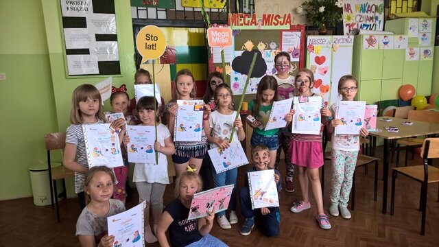 Grupa uczniów prezentuje swoje dyplomy.