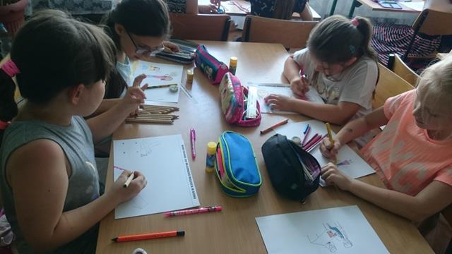   Zdjęcie przedstawiające uczennice podczas zajęć. Dziewczęta siedzą przy stołach i rysują. 