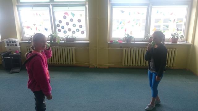 Dwie uczennice podczas zajęć w świetlicy szkolnej. Dziewczynki improwizują rozmowę przez telefon. 