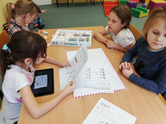Dzieci wykonują zadania związane z kodowaniem.