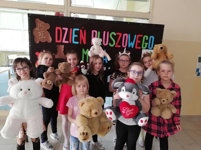 Grupa dziewczynek trzymających różnej wielkości pluszowe misie.