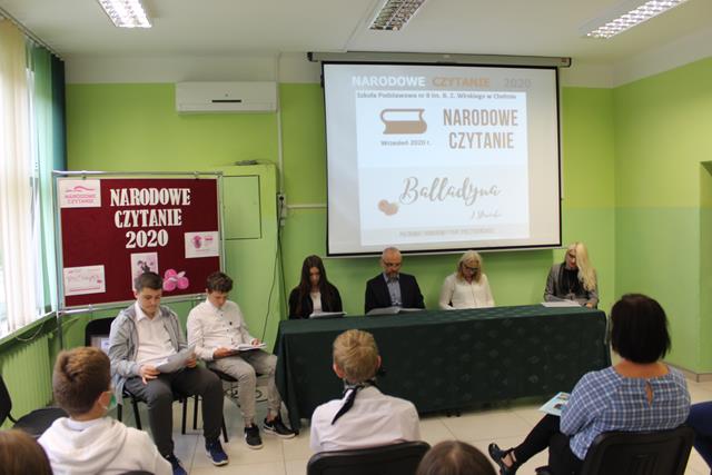 Zdjęcie przedstawiające dyrekcję, zaproszonych gości i uczniów podczas Narodowego Czytania ,,Balladyny’’ w sali konferencyjnej.