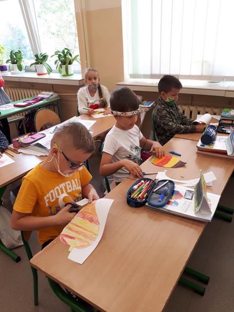 Zdjęcie przedstawiające uczniów w sali lekcyjnej podczas wykonywania prac plastycznych związanych z drzewami.