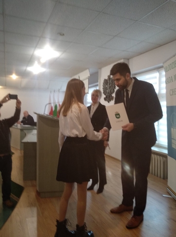 Zdjęcie przedstawia moment wręczenia uczennicy dyplomu przez prezydenta miasta. 