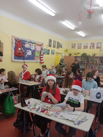 Zdjęcie przedstawia uczniów podczas zajęć warsztatowych. Dzieci wykonują prace manualne o tematyce świątecznej.