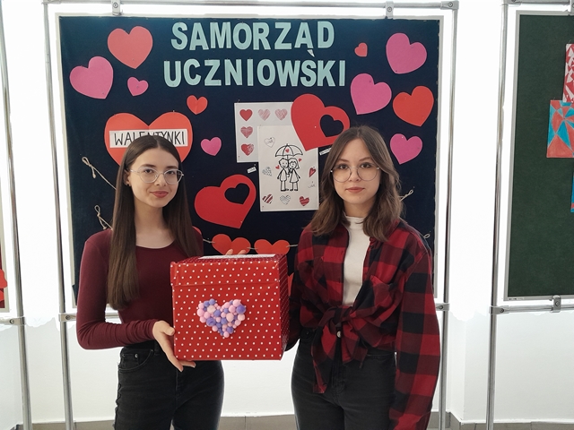 Dwie uczennice prezentują skrzynkę poczty walentynkowej.