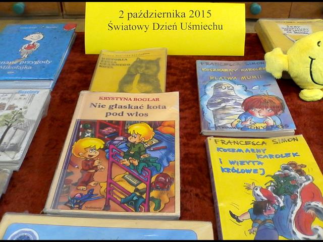 Rozłożone książki, których treść zmusza do śmiechu. Wśród nich napis: „2 października 2015 Światowy Dzień Uśmiechu”.