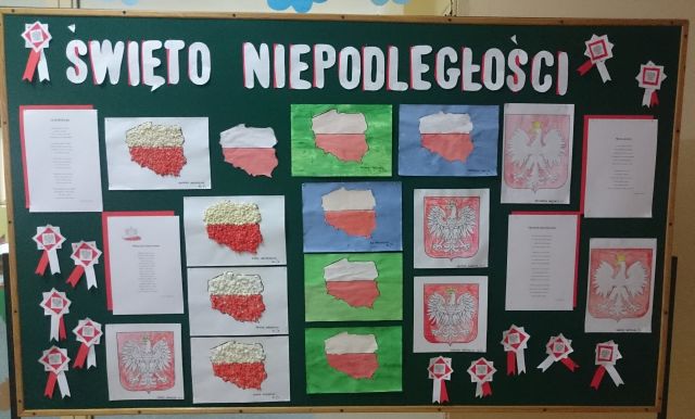 Zdjęcie tablicy z pracami uczniów ukazującymi symbole narodowe.