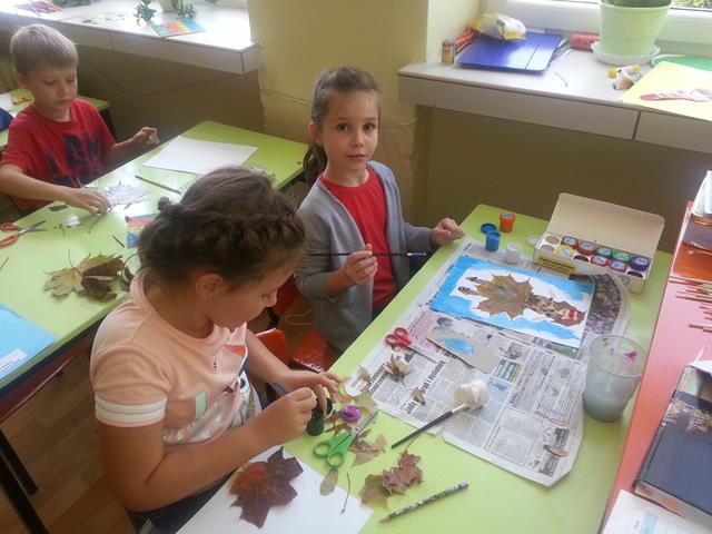 Zdjęcie przedstawiające uczniów podczas wykonywania prac plastycznych o tematyce jesiennej.