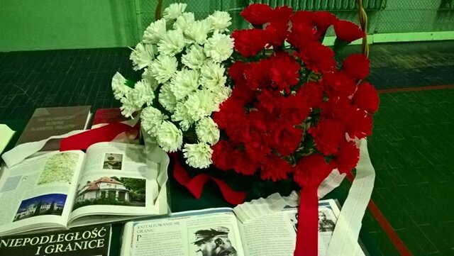 Kosz biało-czerwonych kwiatów oraz wystawa książek o tematyce patriotycznej. 