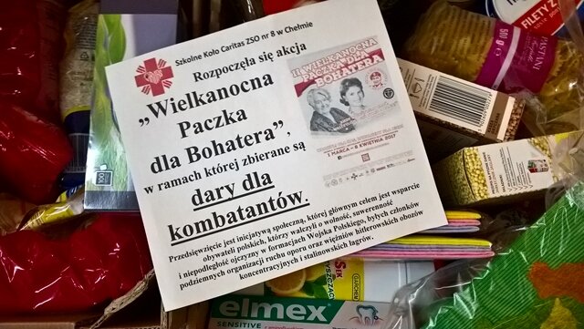 Dary zebrane dla kombatantów, na których leży kartka z logo akcji „Wielkanocna Paczka dla Bohatera”.