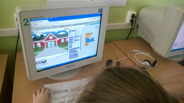 Zdjęcie przedstawiające ekran komputera i uczennicę podczas lekcji informatyki. 