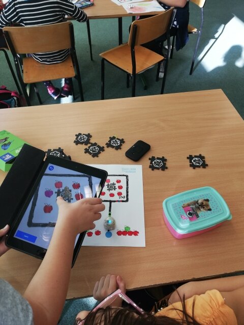 Zajęcia z programowania. Uczniowie wykonują zadania z puzzlami oraz wytyczają tor dla Ozobotów.
