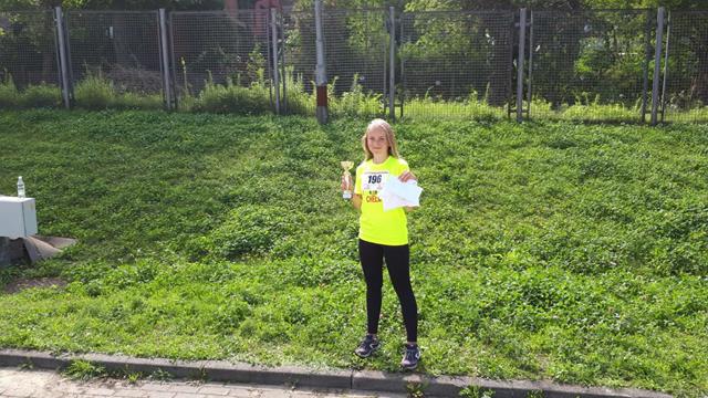 Uczennica klasy VI a Kinga Zacharczuk w plenerze prezentuje puchar oraz brązowy medal zdobyty w Ogólnopolskich Finałach LA.