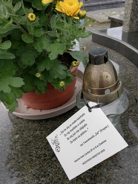 Na pomniku żółte chryzantemy i znicz z dedykacją, w czyjej pamięć pozostaje zmarły.