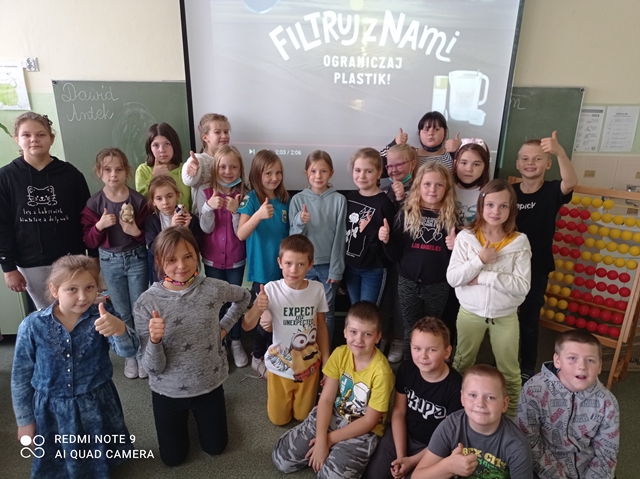 Fotografia prezentująca uczniów klasy 3c uczestniczących w projekcie ekologicznym “Filtruj z nami”.