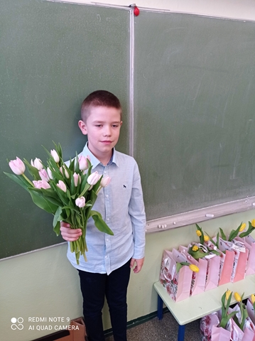 Uczeń z tulipanami dla koleżanek z okazji Dnia Kobiet.