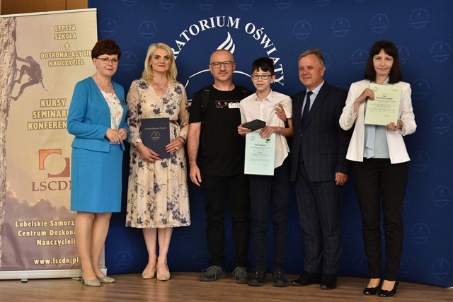 Zdjęcie przedstawiające ucznia podczas odbioru nagród za zdobycie tytułu laureata w konkursie historycznym organizowanym przez Lubelskiego Kuratora Oświaty. 