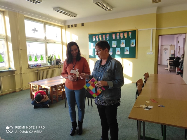 Zdjęcie przedstawia Panie z Chełmskiej Biblioteki Pedagogicznej podczas warsztatów. Prowadzące zajęcia pokazują zakładki do książek. 