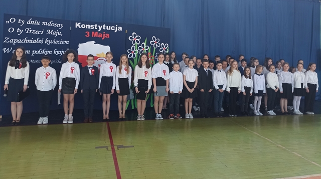 Zdjęcie przedstawia grupę uczniów podczas akademii z okazji rocznicy uchwalenia Konstytucji 3 Maja.