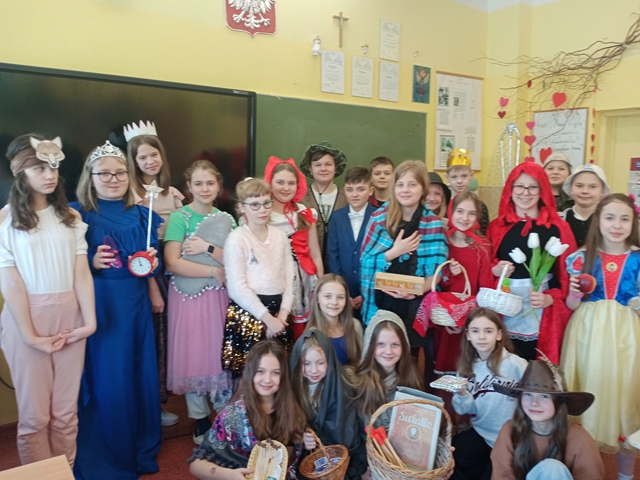 Zdjęcie przedstawia grupę uczniów w baśniowych strojach zgromadzonych w sali lekcyjnej.