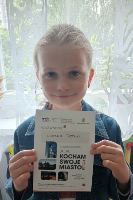 Uczennica Wiktoria Petruk prezentuje dyplom zdobyty w miejskim konkursie plastycznym „A ja kocham swoje miasto”.