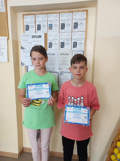 Dwoje uczniów prezentuje swoje dyplomy zdobyte w  międzyszkolnym konkursie „Zawód moich marzeń”.