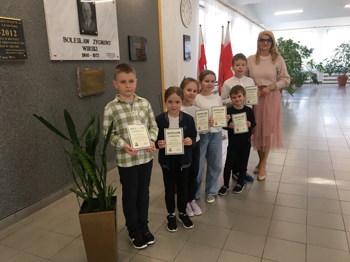 Dzieci z dyplomami pozują do wspólnego zdjęcia z Panią Dyrektor.